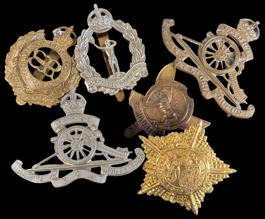 a selection of fake British Army Corps cap badges.