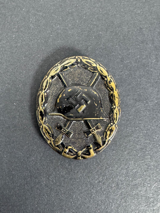 German black wound badge, brass with black painted finish. crossed sword, combat helmet and third Reich symbol.