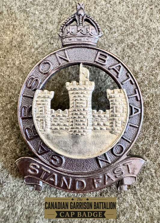frontal view of the garrison battalion officer cap badge on a khaki background.