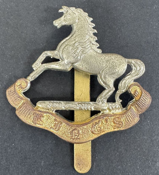 a cap badge of the king's liverpool regiment. horse over banner "king's"
