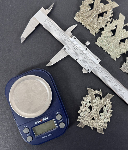 Medals Militaria blog post on spotting fake cap badges and medals. image shows cap badges, calipers, and scales.