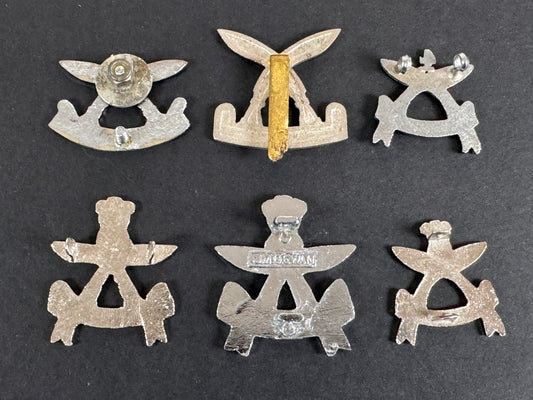 Set of six silver gurkha assam rifles military insignia badges on a dark background
