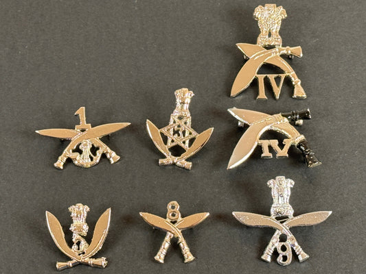 Set of silver military gurkha insignia badges on a gray background