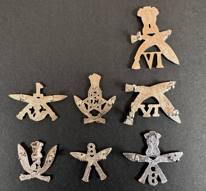 Set of silver gurkha rifles cap badges on a dark gray background