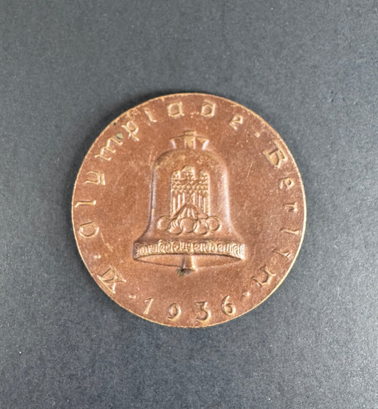 Bronze table medal with embossed design on a gray background. For 9th Olympiad Berlin 1936.