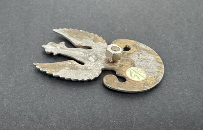 Metallic object with a unique design on a gray background