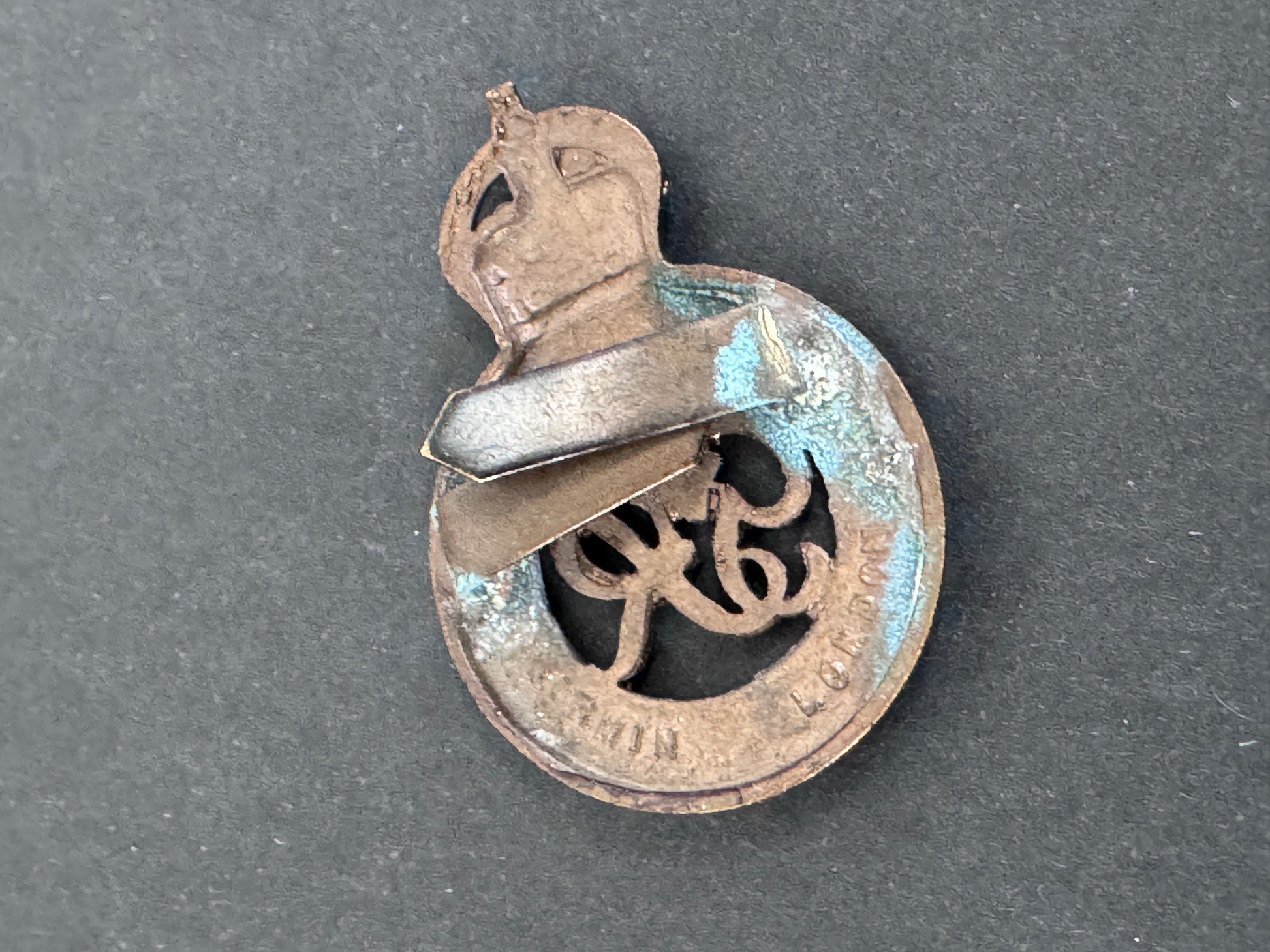 Metallic badge with intricate design on a gray background
