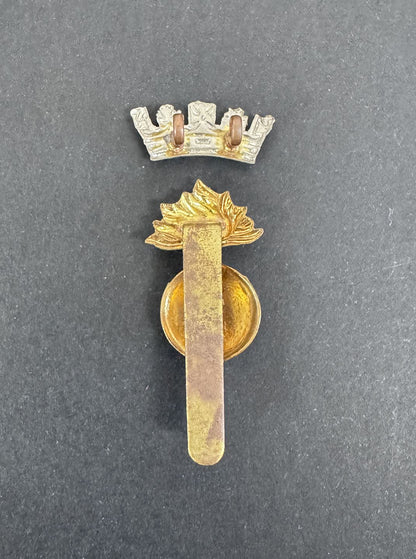 Gold military insignia badge with a crown on a gray background