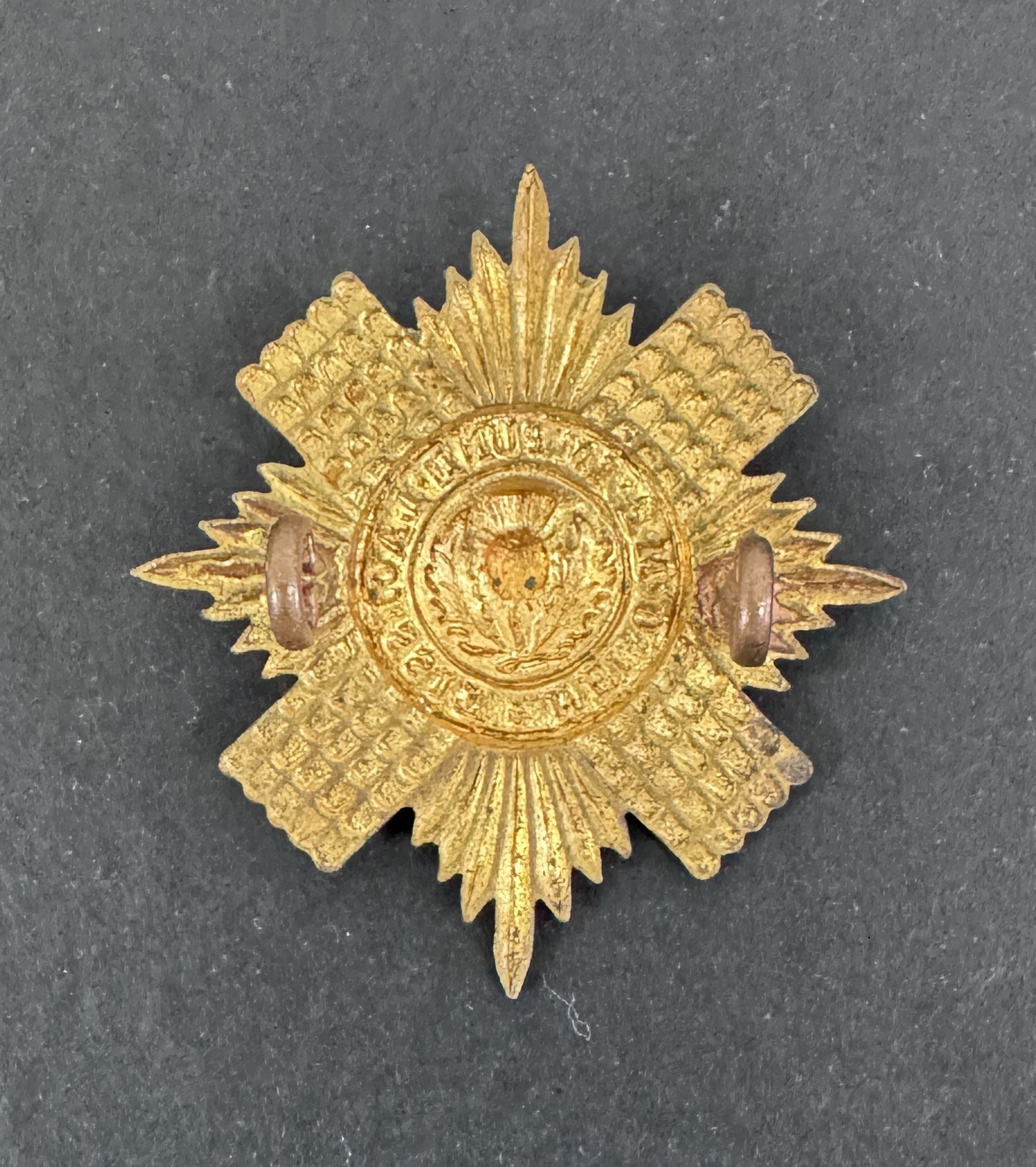 Gold star-shaped military badge on a dark gray background