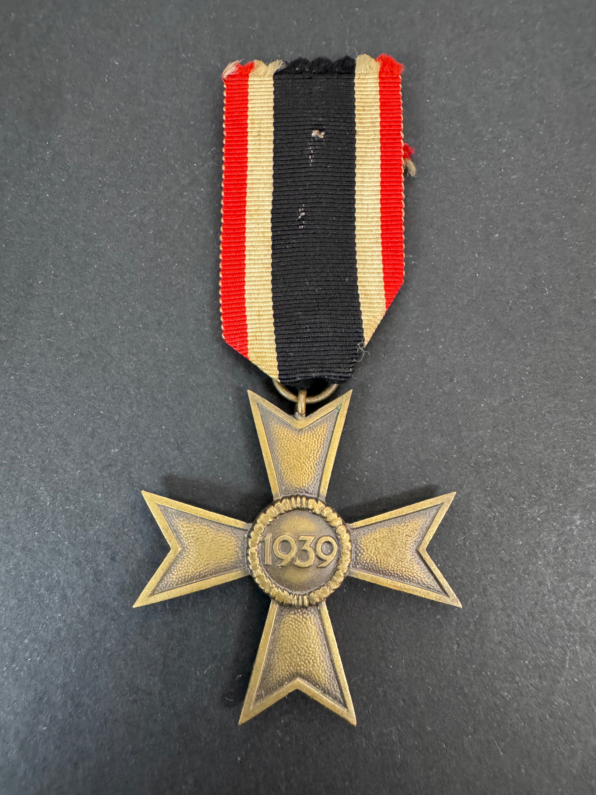 Medal with a striped ribbon on a dark background. 1939 date.