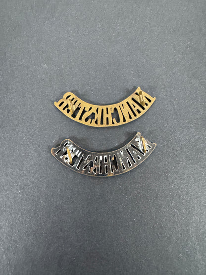 British Army Manchester Regiment Shoulder Title Badges (Pair) – A matching pair of original uniform shoulder titles of the...