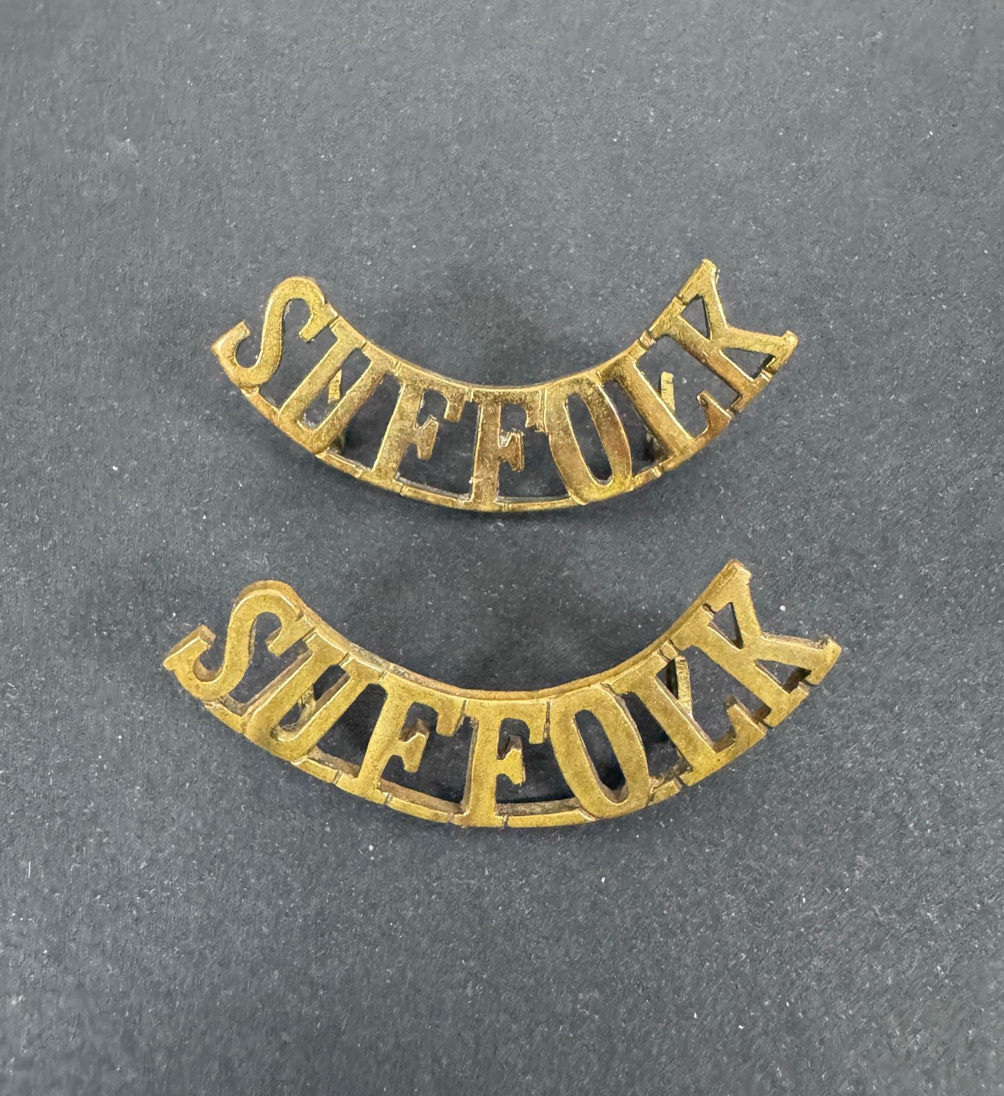 British Army Suffolk Regiment Shoulder Title Badges (Pair) – A matching pair of original uniform shoulder titles of the Su...