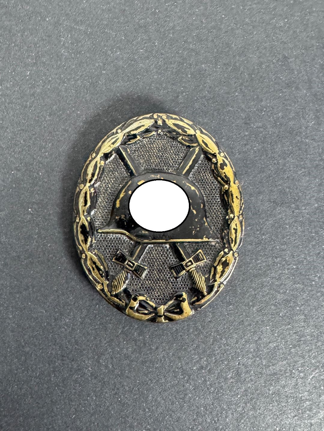 German black wound badge, brass with black painted finish. political symbol blanked out.