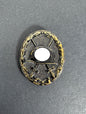 German black wound badge, brass with black painted finish. political symbol blanked out.