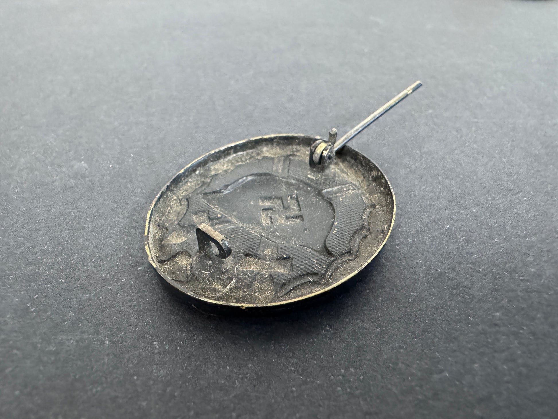 German black wound badge, brass with black painted finish. reverse view, angled for view of the mount system.