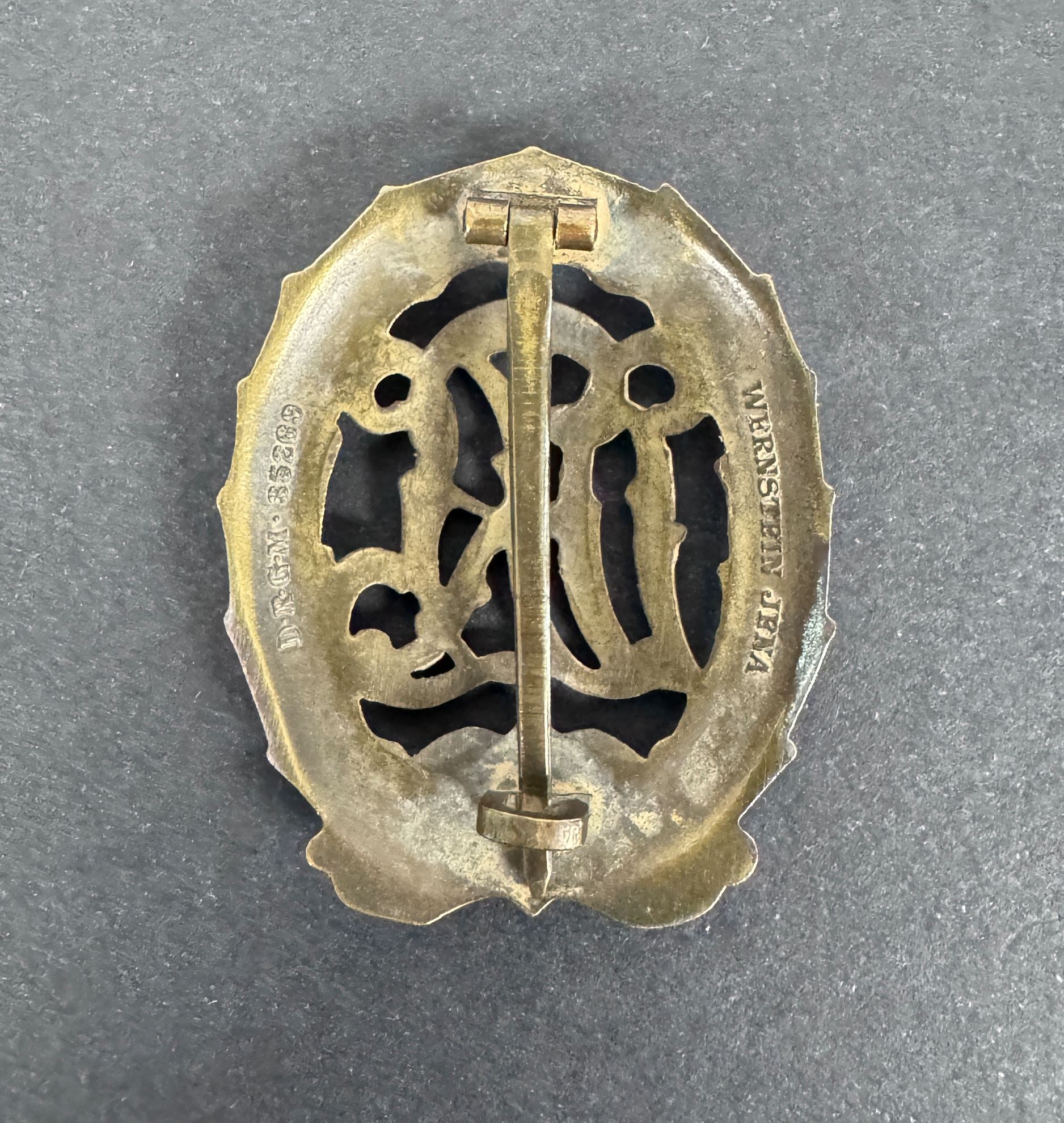 German D R L sports badge in bronze reverse view. mount pin and maker mark "Wernstein Jena".