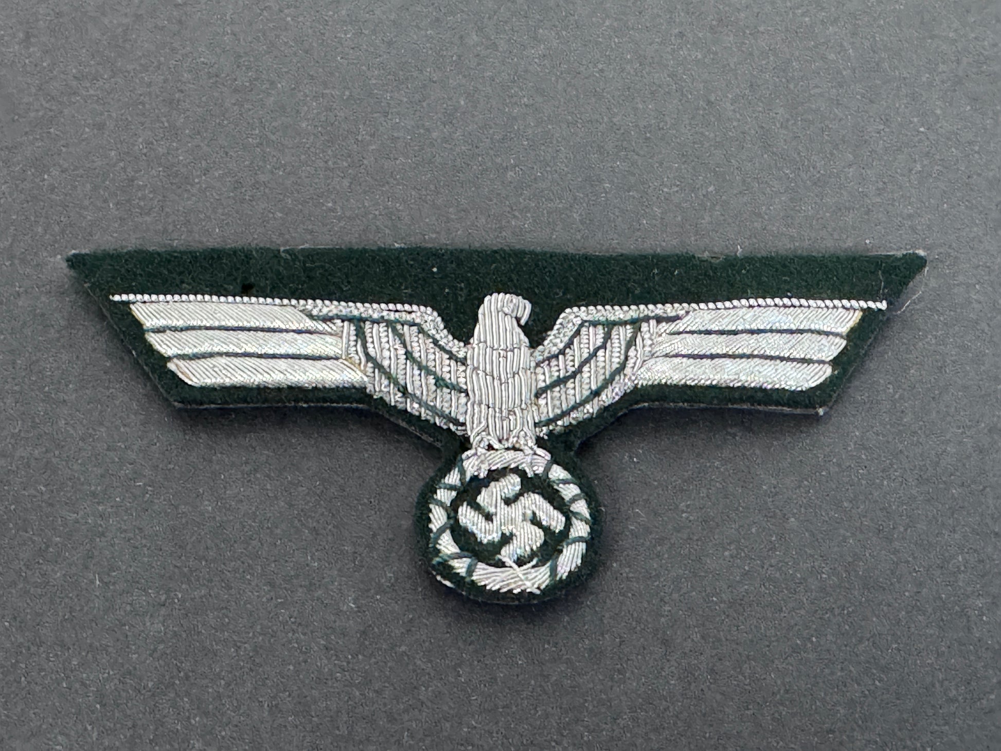 Nazi eagle badge with swastika on a gray background. worn by army officer's on the tunic breast.