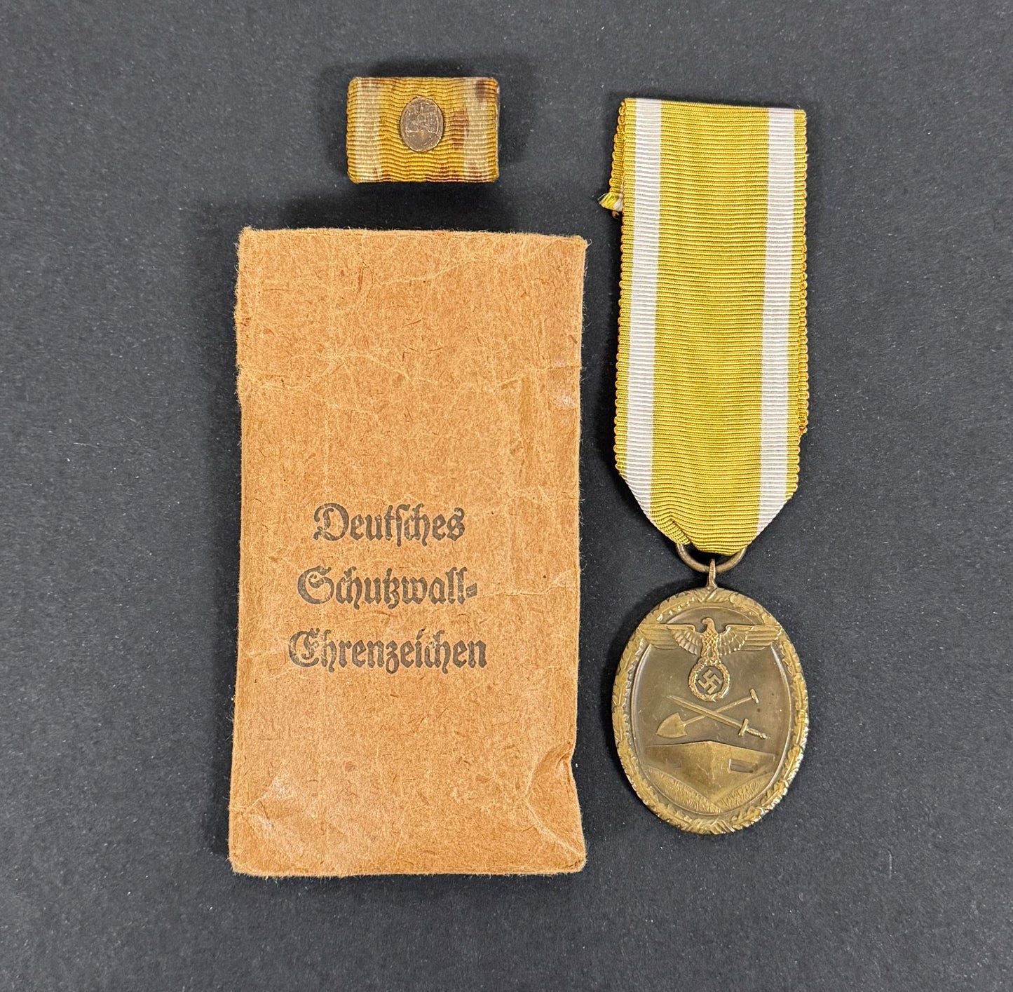 WW2 German Westwall Medal & Issue Packet – A Westwall medal with issue packet and a ribbon bar and device of the