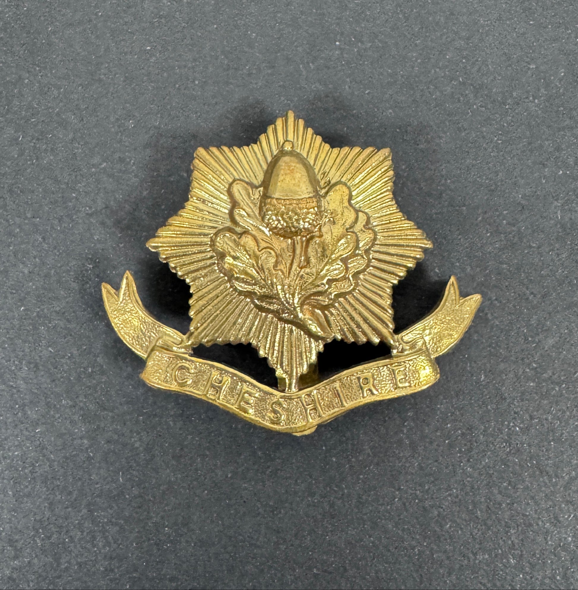 WW1 British Army Cheshire Regiment War Economy Cap Badge – An original other ranks war economy cap badge of The Cheshire R...