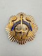 Gold and blue naval insignia on a gray background